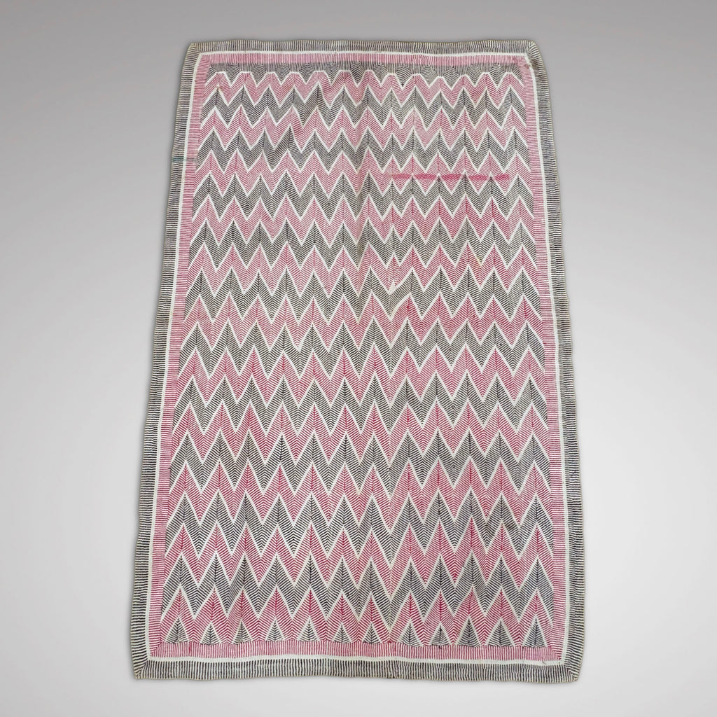 Main Picture 2 -An rectangular Kantha throw or quilt with a pink, gray, and white chevron pattern and a gray border, shown flat against a neutral grey background.